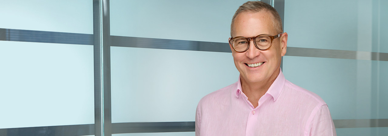 A photograph of registered patent agent David Johnson wearing a pink shirt and glasses.